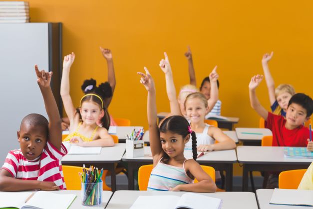 Kids raising hands in classroom