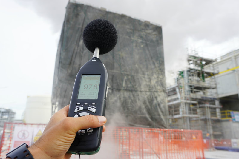 holding sound level meter measuring noise