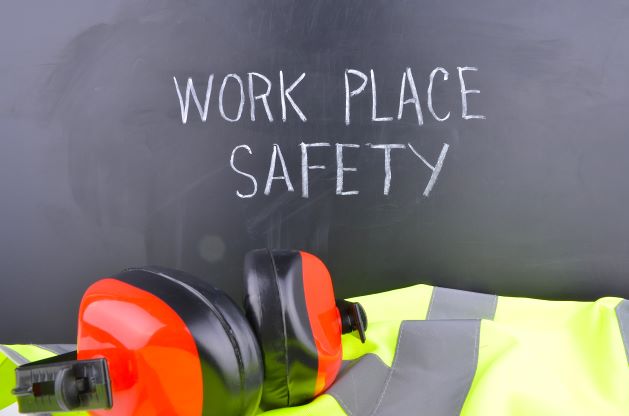 hearing protection and safety vest in front of blackboard